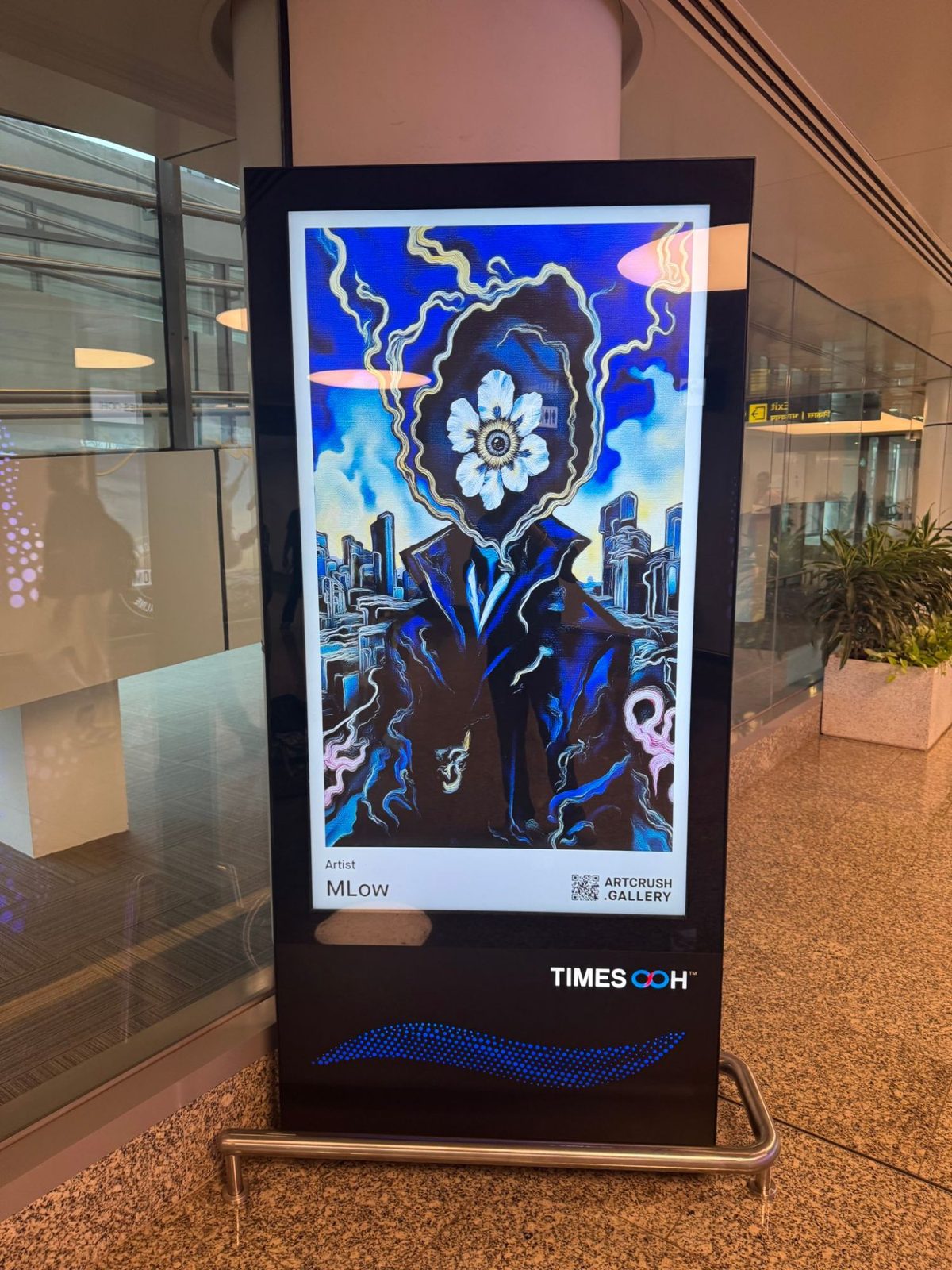 MLow's flower-headed figure on a Times OOH screen in an Indian airport