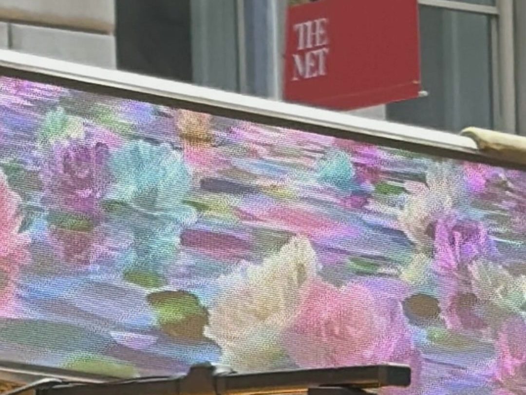 Endless Peonies on a taxi top screen beside a banner for The Met, New York