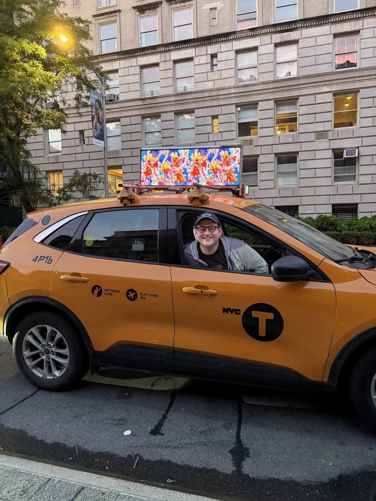 MLow in the back of a New York taxi with The Evolution of fLOWers playing on the taxi top