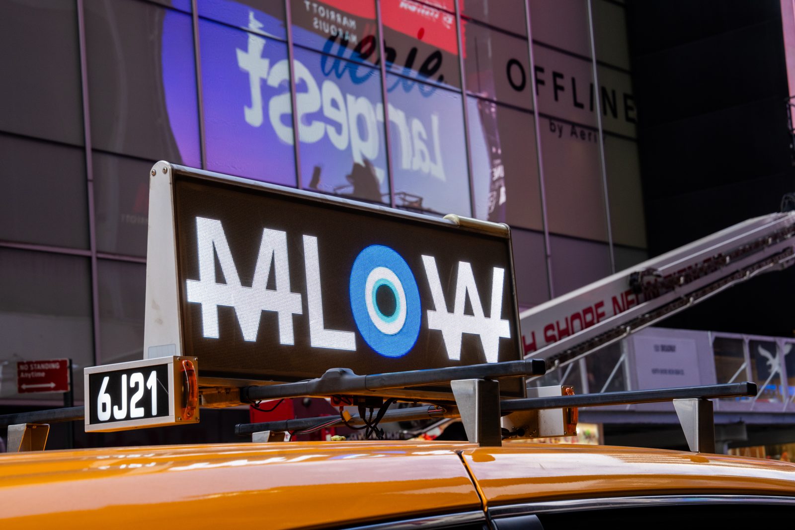 A New York taxi top screen reading MLOW